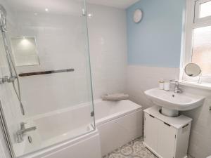 ein weißes Badezimmer mit Dusche und Waschbecken in der Unterkunft Cosy Cottage in Morpeth + 21 Fotos