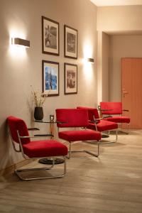 una sala de espera con sillas rojas y una mesa en Silva Hotel Spa-Balmoral en Spa