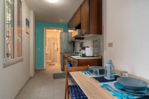 una cocina con una mesa y una encimera en RivieraRent Bettina Holiday, en Finale Ligure