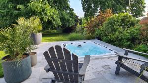 einen Whirlpool auf einer Terrasse mit einem Stuhl in der Unterkunft Villa 35 minutes Paris in Saint-Prix