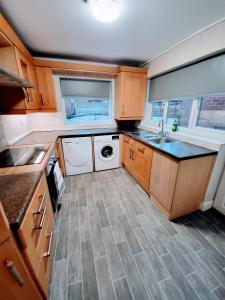 eine kleine Küche mit Waschmaschine und Trockner in der Unterkunft Burns Street - Stay Sleep Rest in Nottingham