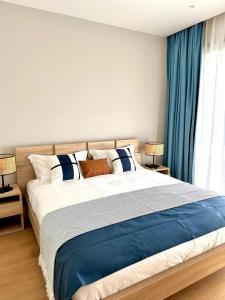 a bedroom with a large bed with blue curtains at Serena Village Tulear in Toliara