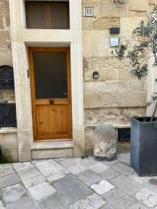 a building with a wooden door and a stone wall at La Monaca Salentina in Lecce