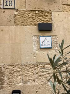 a sign on the side of a brick wall at La Monaca Salentina in Lecce