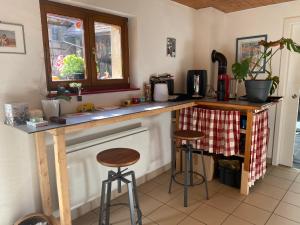 a kitchen with a counter and stools in a room at La ferme de Lili in Truchtersheim