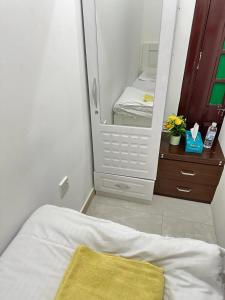 una camera da letto con specchio e letto con coperta gialla di Cornich AD - Pearl Room a Abu Dhabi