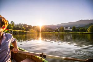 uma pessoa em um barco em um lago em Hotel zur Post em Goldegg