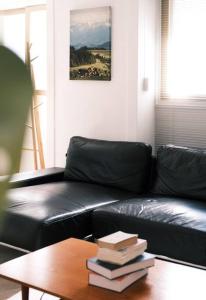 a black leather couch with books on a table at Stay Naroseoda in Incheon