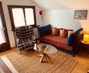 a living room with a couch and a table at mansardacourmayeur in Courmayeur