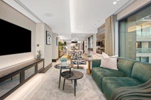 a living room with a green couch and a tv at Aurum 501 in Cape Town