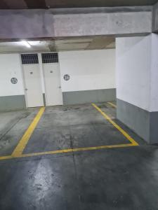 an empty parking garage with white and yellow doors at Central y con todas las comodidades 2 in Santiago