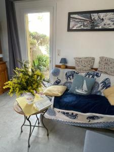 uma sala de estar com uma cama e uma mesa em LES MIMOSAS em Saint-Trojan-les-Bains