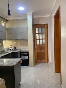 a kitchen with a door and a counter top at Veron’s Elegant Home in Munyonyo