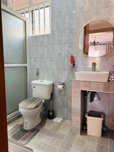a bathroom with a toilet and a sink and a mirror at Veron’s Elegant Home in Munyonyo