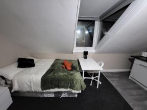 a bedroom with a bed and a desk and a window at Burns Street - Stay Sleep Rest in Nottingham