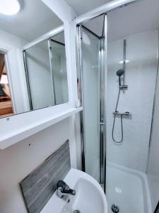 a bathroom with a sink and a shower and a mirror at Burns Street - Stay Sleep Rest in Nottingham