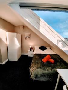 a bedroom with a bed with an orange pillow on it at Burns Street - Stay Sleep Rest in Nottingham