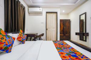 1 dormitorio con cama blanca y manta colorida en FabHotel Hamsa The Right Choice en Hyderabad