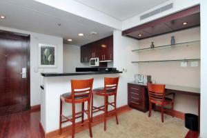 a kitchen with a bar with three stools at George V - Itaim in São Paulo