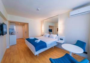 um quarto com uma cama, uma mesa e cadeiras em Panorama Sea View Orbi City Aparthotel em Batumi