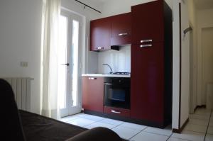 cocina con armarios rojos, fregadero y fogones en Appartamenti Le Spiagge, en Marciana Marina