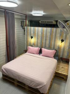 una camera da letto con un grande letto con cuscini rosa di La Locanda a Bangkok