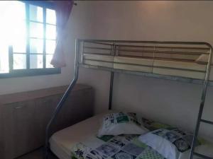 Łóżko piętrowe w niewielkim pokoju z oknem w obiekcie Le Monstera w mieście Le Lambert