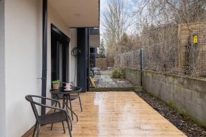 a patio with a table and chair and a fence at Apartment in Krakow with parking and balcony by Renters in Modlnica