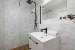 a white bathroom with a sink and a shower at Apartment in Krakow with parking and balcony by Renters in Modlnica