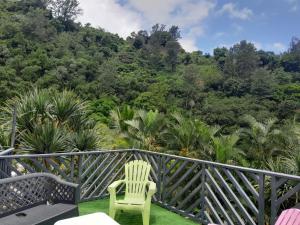a balcony with a chair and a view of a forest at Le Monstera in Le Lambert