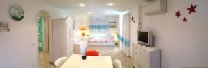 a living room with a tv and a bedroom at Sardegna Beach Cala Reale in Santa Marinella