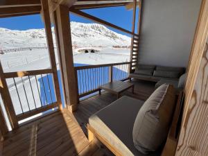 a balcony with a couch and a view of snow covered mountains at Résidence Phoenix C by Leavetown Vacations in L'Alpe-d'Huez