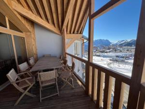 a wooden balcony with a table and chairs on it at Résidence Phoenix C by Leavetown Vacations in L'Alpe-d'Huez