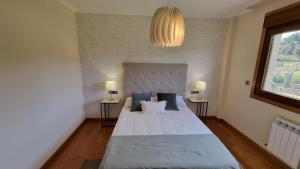 1 dormitorio con 1 cama grande con almohadas azules en casa de lujo con pisicina y jardin en el rural en Meis