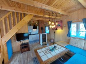 a living room with a blue couch in a cabin at Domki Karaibskie in Sasino