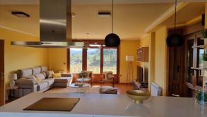 cocina y sala de estar con paredes amarillas en casa de lujo con pisicina y jardin en el rural en Meis