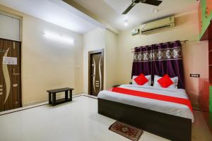 a bedroom with a bed with red pillows at Super OYO Flagship Hotel Rudraksh Inn in Rānchī