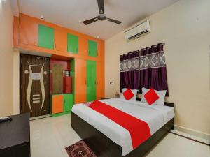 Schlafzimmer mit einem Bett mit roten und grünen Streifen in der Unterkunft Super OYO Flagship Hotel Rudraksh Inn in Ranchi