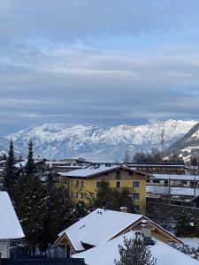 une ville avec des montagnes enneigées en arrière-plan dans l'établissement Marina Alpen Haus, à Zell am See