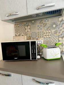 a microwave sitting on top of a counter with a toaster at L’Angolo Degli Dei in Agrigento