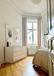 ein weißes Schlafzimmer mit einem Bett und einem Fenster in der Unterkunft Lägenhet i centrala Stockholm in Stockholm