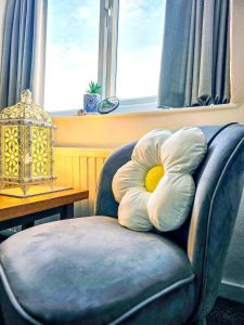 ein Kissen auf einem Stuhl in einem Zimmer mit einem Fenster in der Unterkunft Beachcomber B&B in Tenby