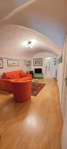 a living room with an orange couch in a room at Suite dei Doria in Dolceacqua