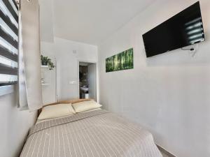 a bedroom with a bed and a flat screen tv at Apartments Hajl in Krk