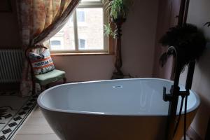a bath tub in a bathroom with a window at Victorian Farrar Cottage in York