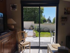 a living room with a sliding glass door to a patio at Maisonnette en campagne au calme in Carpentras