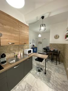 a kitchen with a sink and a counter with a table at Ennio Rooms in Bari
