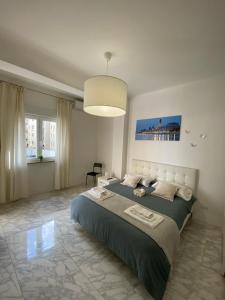 een slaapkamer met een groot bed en een hanglamp bij Ennio Rooms in Bari