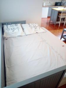 a bed with white sheets on it in a room at VERICA in Samobor