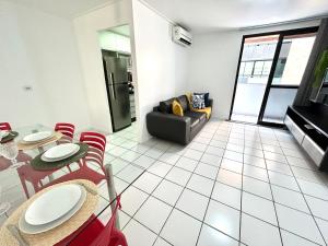 uma sala de estar com uma mesa e cadeiras e um sofá em Apartamento Beira Mar de Pajuçara / Maceió em Maceió